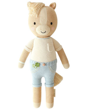 Liam the Pony - Regular 20" by Cuddle + Kind is a charming stuffed animal doll featuring a tan body, light blue pants, a cream shirt with a stitched pocket, and a soft yarn tail—this adorable friendship plush makes an ideal birthday gift and is photographed against a white background.