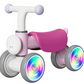 The Freddo Nature Navigator Balance Bike is a small pink and white ride-on for toddlers, featuring four wheels with colorful LED tire lights, thoughtfully designed for sensory discovery.