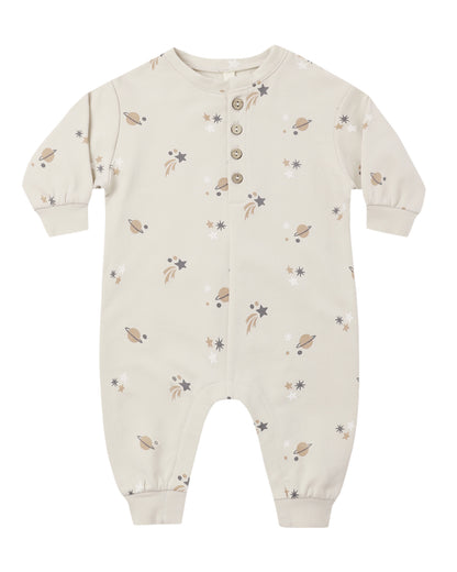 The Quincy Mae Baby Relaxed Fleece Jumpsuit is a beige long-sleeve onesie featuring a cozy fleece fabric, convenient button closure, and a space-themed print with planets, stars, and comets—an everyday essential designed for comfort.