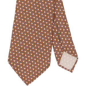 Sid Mashburn Silk Print Tie in orange, featuring a repeating geometric pattern of interlocking shapes in brown, white, and purple; this 8cm wide tie is pictured with the tip folded to display the reverse side.