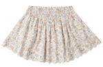 The Girls' Smocked V Mini Skirt by Rylee & Cru showcases a light floral pattern, smocked waistband, and scalloped hem. Pictured laid flat on a white background.