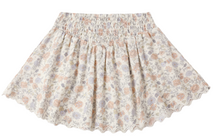 The Girls' Smocked V Mini Skirt by Rylee & Cru showcases a light floral pattern, smocked waistband, and scalloped hem. Pictured laid flat on a white background.