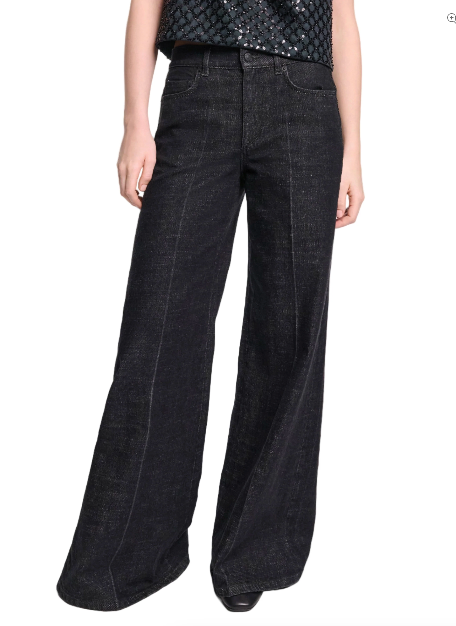 A person models the Dorothee Schumacher Deep Love Pants, styled in a dark wash wide-leg fit, paired with a sleeveless patterned top and stands with arms relaxed by their sides.