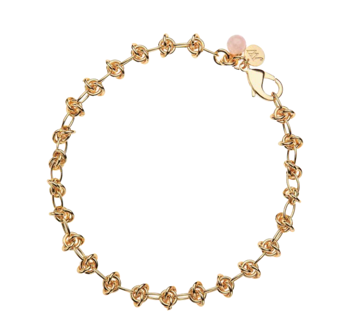 Gold chain bracelet with knot links, a pink bead, and a round gold charm near the clasp—perfect for pairing with your favorite Jane Win pendant chains from our Necklace Chain Collection.