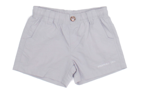 The Properly Tied Boys' Mallard Short in light grey features an elastic waistband, front pockets, a center button, small printed text on the right leg, and quick-dry fabric for all-day comfort.