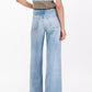 Person wearing Rag & Bone’s Miramar Terry Sofie Wide Pant in light blue and a short-sleeve, striped knit top, standing with their back to the camera.