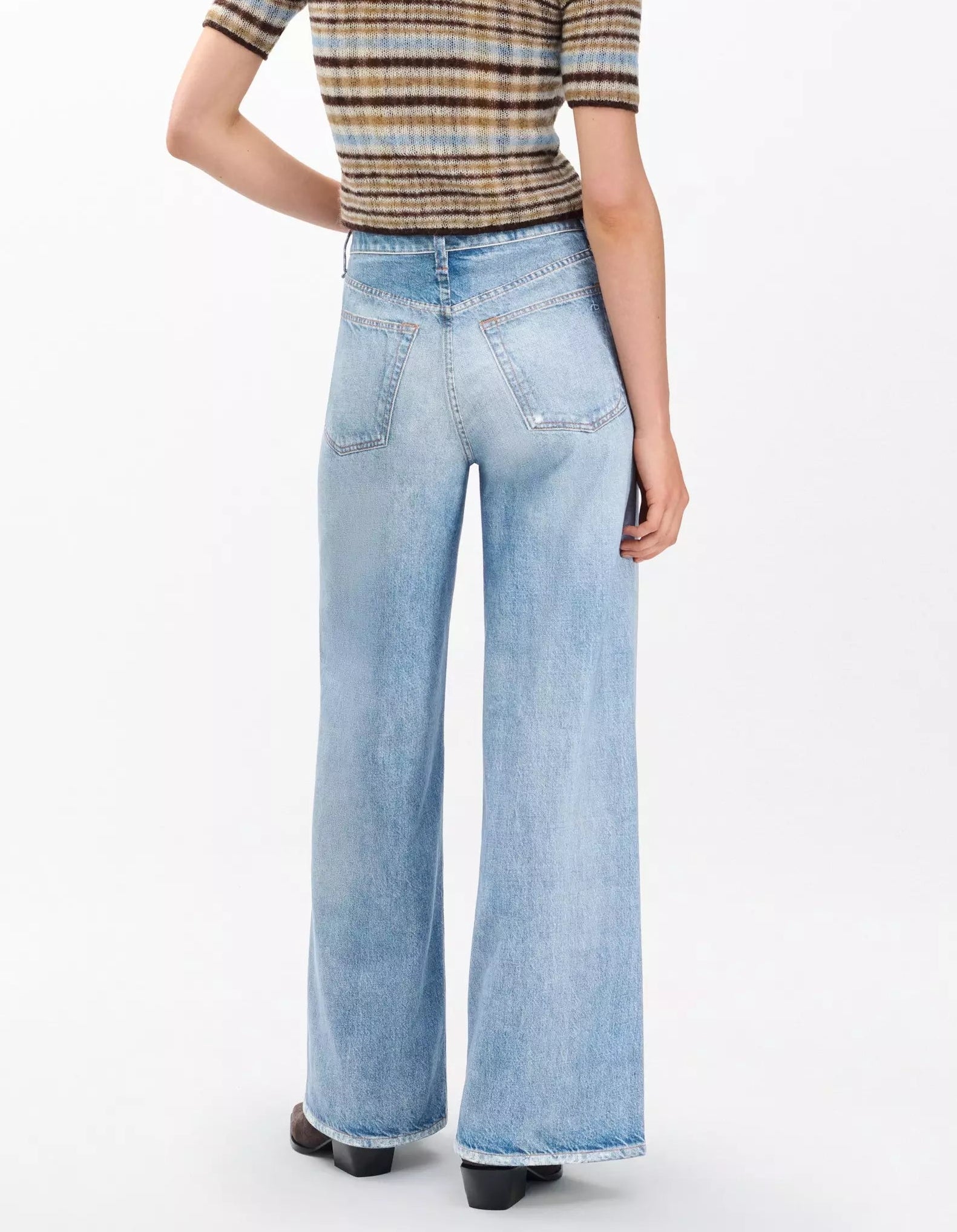 Person wearing Rag & Bone’s Miramar Terry Sofie Wide Pant in light blue and a short-sleeve, striped knit top, standing with their back to the camera.