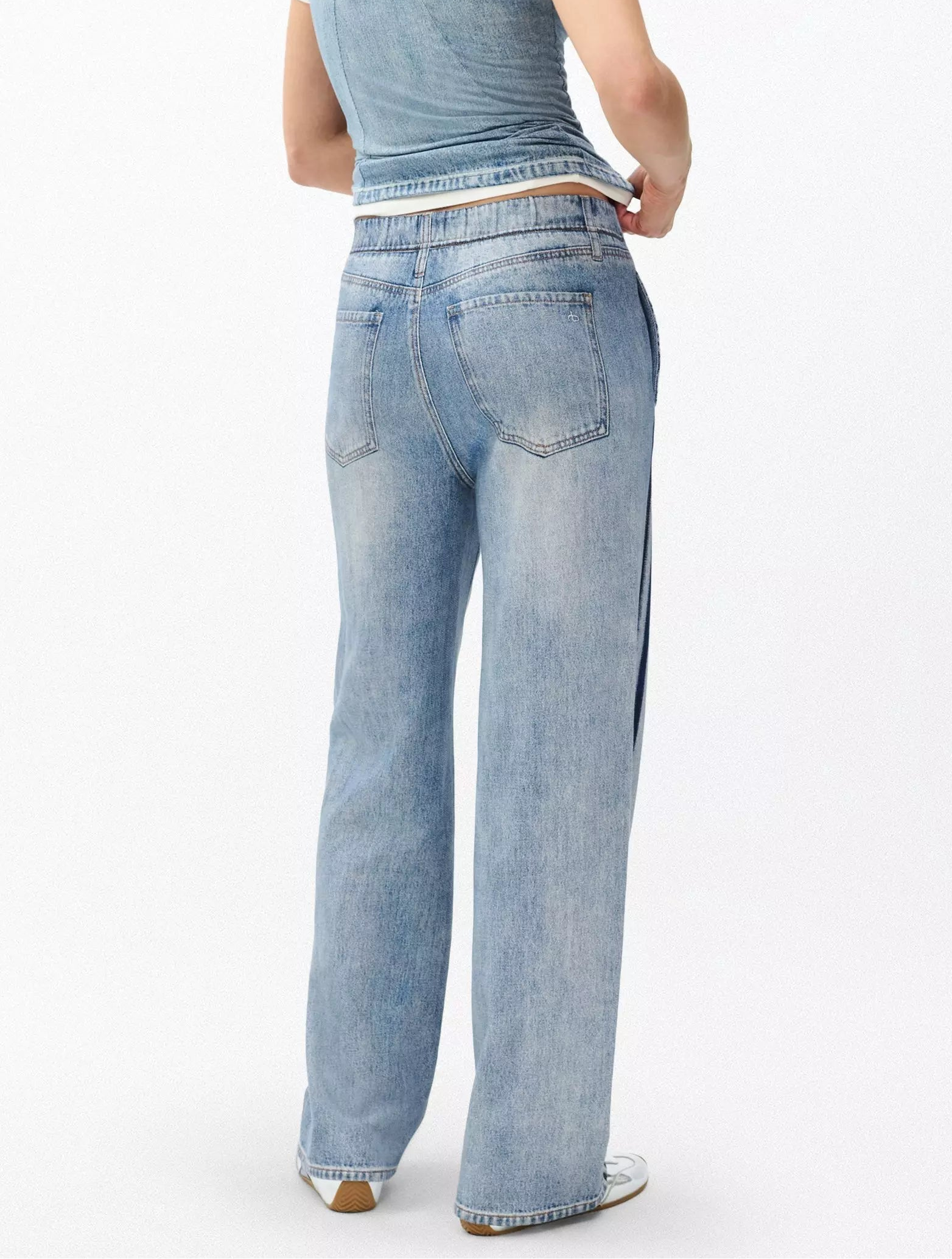 A person wearing Rag & Bone’s Miramar Terry Wide Track Pant in light blue with a sleeveless denim top, shown from the back against a plain white background.