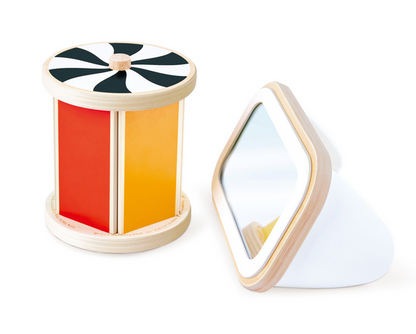 The Hape Spinning Drum w/ Mirror is a wooden sensory toy designed as a developmental baby toy, featuring black and white stripes, red and yellow panels, and a triangular tummy time mirror with a wooden frame and white stand—perfect for encouraging sensory play.