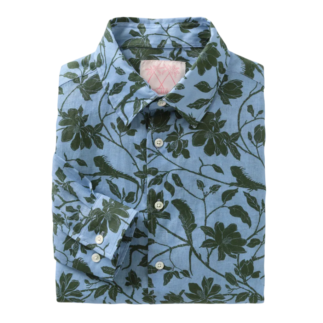 A neatly folded Pink House Mustique Printed Linen Shirt featuring long sleeves and a green floral pattern on a light blue background, capturing the laid-back elegance of Mustique.