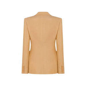 The Renegade Charmer Blazer by Blaze Milano in sand linen is shown from the back, highlighting its long sleeves and cuff button details.