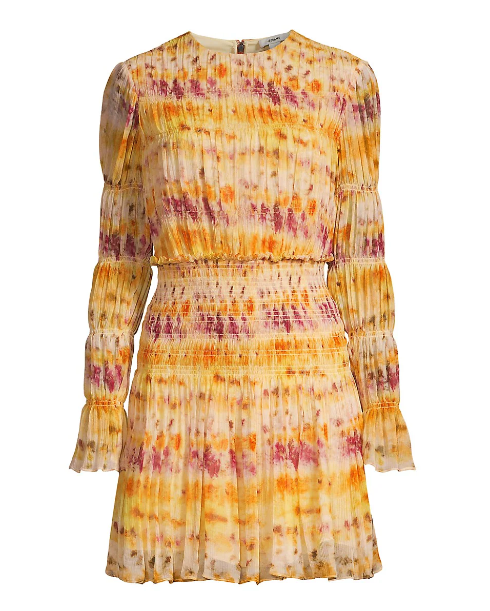 The Jason Wu Printed Silk Crinkle Chiffon Dress features long sleeves, a mini length, a pleated design, and a yellow-orange-pink tie-dye pattern with a fitted smocked waist and cuffs.