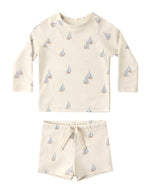 The Rylee & Cru Baby Boys' Rashguard Set features long sleeves in off-white with blue and orange sailboat prints. This UPF 50+ swimwear offers stylish sun protection for all your child’s water adventures.