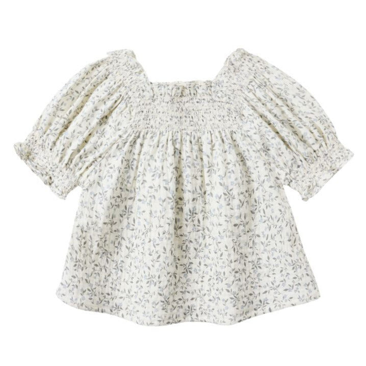 The Girls' Ada Blouse by Rylee & Cru is a cream, short-sleeved smocked top with a small floral print, square neckline, and subtle puff sleeves for a charming touch.
