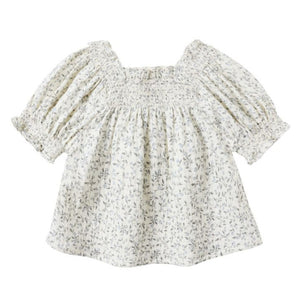 The Girls' Ada Blouse by Rylee & Cru is a cream, short-sleeved smocked top with a small floral print, square neckline, and subtle puff sleeves for a charming touch.