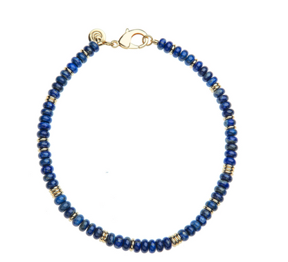 The Gumdrop Beaded Necklace Collection by Jane Win features a bracelet with alternating blue and gold round beads, finished with a gold lobster clasp. It pairs perfectly with the matching statement necklace for a coordinated look.