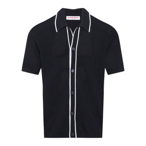 The Orlebar Brown Roddy Button Through Knitted Shirt is a short-sleeve black waffle mesh style with white piping at the collar, placket, and pocket seams, finished with textured summer tailoring and a "Chelsea Brown" label inside.