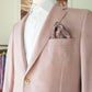 Mannequin dressed in a Samuelsohn Baylor Blazer, a light pink suit jacket featuring a single button and a patterned pocket square, over a white shirt, showcasing Samuelsohn's luxury men's clothing and superior craftsmanship.