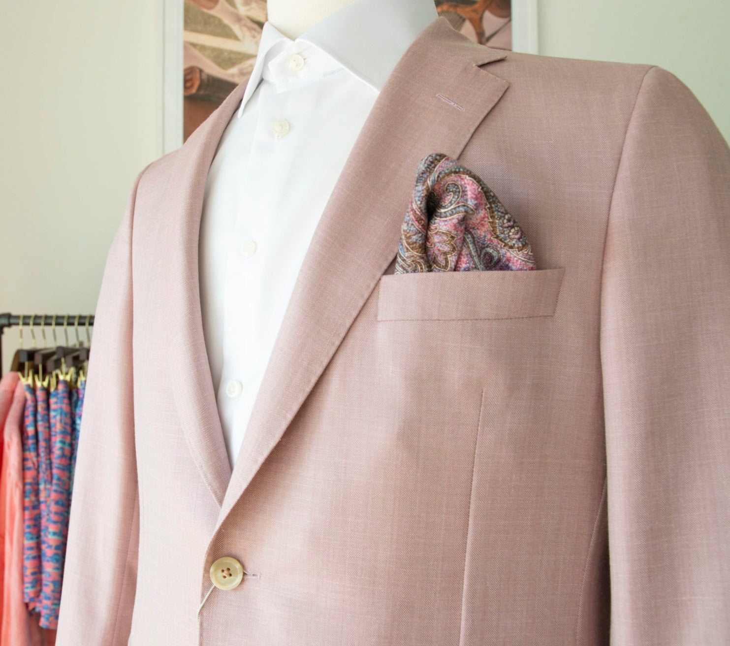 Mannequin dressed in a Samuelsohn Baylor Blazer, a light pink suit jacket featuring a single button and a patterned pocket square, over a white shirt, showcasing Samuelsohn's luxury men's clothing and superior craftsmanship.