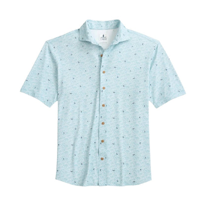 The Johnnie-O Rowing Shirt is a light blue, short-sleeve button-up featuring a subtle small pattern inspired by surf culture, wooden buttons, and a collar, displayed laid flat on a white background.
