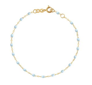 The Little Gigi Classic Bracelet 5.1" by Gigi Clozeau showcases an elegant 18-carat gold chain with small light blue bead accents, beautifully set against a white background.