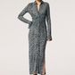 Wearing the Altuzarra Claudia Dress, a long-sleeve, button-down, ankle-length style in blue and black abstract jersey fabric, paired with black ankle boots.