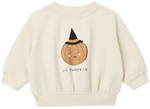 Quincy Mae’s Baby and Kids’ Relaxed Fleece Sweatshirt Lil Pumpkin is a cream-colored, irresistibly cozy essential for everyday wear, featuring a smiling pumpkin in a black witch hat and the text “LIL PUMPKIN” printed below the cheerful illustration.