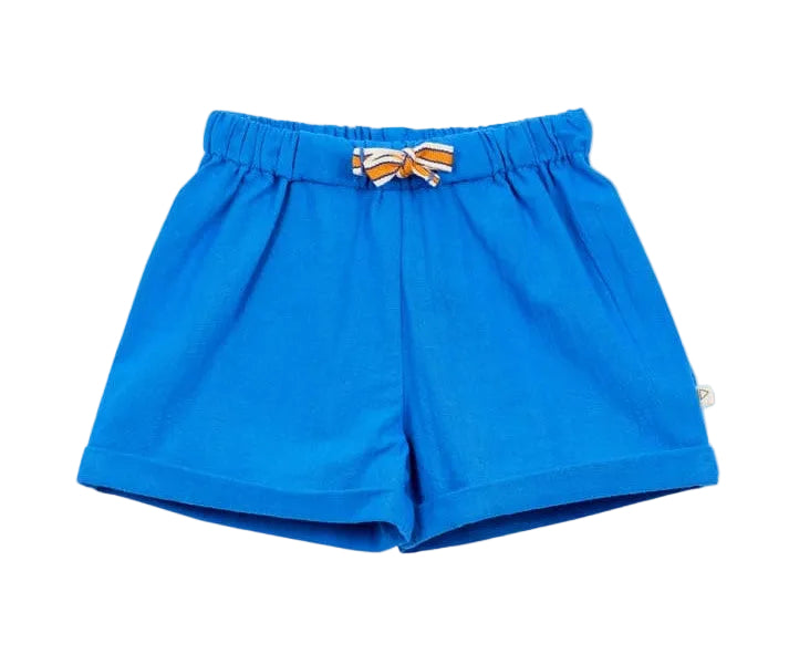 Arsene & Les Pipelettes Baby Boys' Rustic Cotton Baby Short in bright blue, made from textured cotton with an elasticated waist and a small orange and white striped bow at the front, shown on a plain white background.