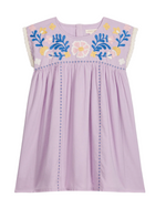 The Girls’ Talula Dress by Louise Misha is a lavender sleeveless dress made from soft cotton veil, adorned with floral embroidery on the chest, delicate lace trim on the shoulders, and blue stitched lines running vertically down the front.