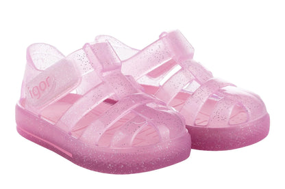 The Igor Girls' Star Jelly Sandal features translucent pink PVC with glitter, closed toes, side straps, and a removable foot bed.