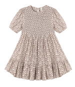 The Girls’ India Dress by Rylee & Cru features short sleeves, a knee-length silhouette, a light brown floral pattern, a smocked bodice, gathered waist, and a ruffled hem.