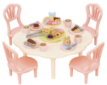 The Calico Critters Sweets Party Set features a vibrant round table with four pink chairs, beautifully arranged with toy food, drinks, animal-shaped treats, and a tiered dessert tray for imaginative tea party play. Complete with adorable teatime accessories, this set inspires endless creative fun and storytelling.