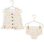 The Lou Lou & Company Baby Girls’ Ruffle Tank & Bloomer Set features a sleeveless floral ruffle tank top made from breathable cotton with oversized buttons and a sweet ruffled hem, paired with coordinating floral bloomers, both shown on gold hangers.