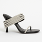 The Simkhai Infinity Crystal Strap Siren Sandal in black has a slim sole, slender heel, and crystal-beaded straps that wrap around the ankle and toe, making it an ideal choice for evening wear.
