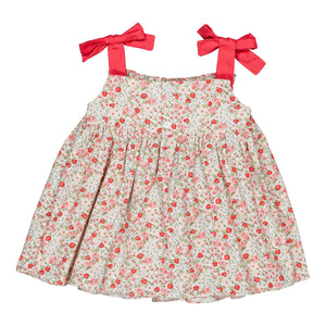 The Kidiwi Baby Girls' Sariette Smocked Blouse features 100% cotton, pink floral and cherry red print, and two wide shoulder straps tied in large red bows.