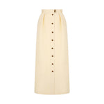 The Savannah Nija Skirt by Blaze Milano is a high-waisted, full-length cream skirt with elegant front pleats and a row of dark buttons down the center.