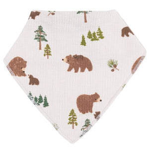 The Angel Dear Bandana Bib features a white, textured fabric with brown bears and green pine trees—ideal for little ones as a stylish teething bib.