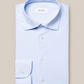 The Eton Four-Way Stretch Shirt, Slim Fit, in light blue features white buttons and a visible brand label, delivering tailored comfort on a neutral background.