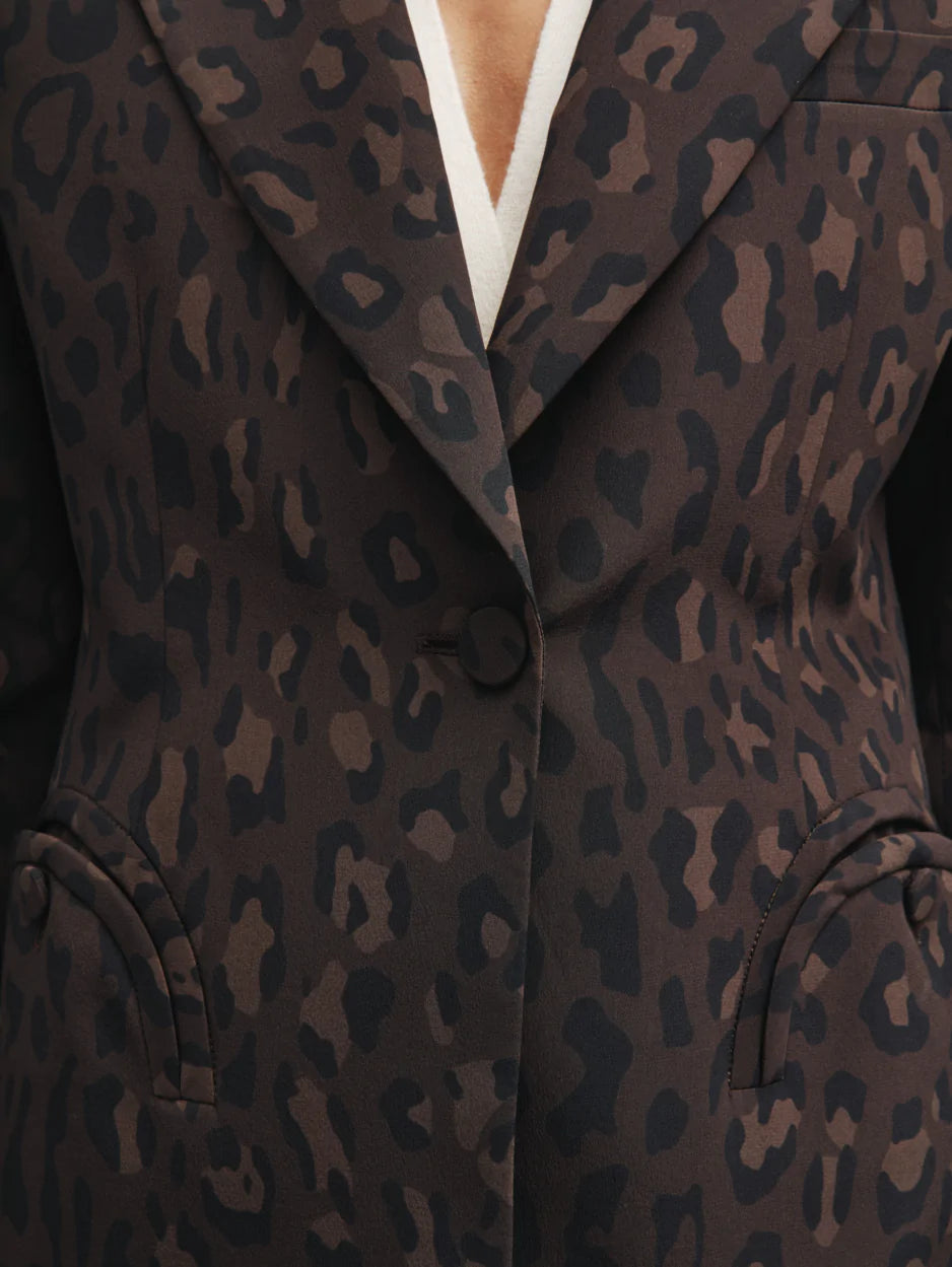 Close-up of a person wearing the Simba Daisy Blazer by Blaze Milano, featuring a chic women's leopard print design over a white top with a single front button fastened.
