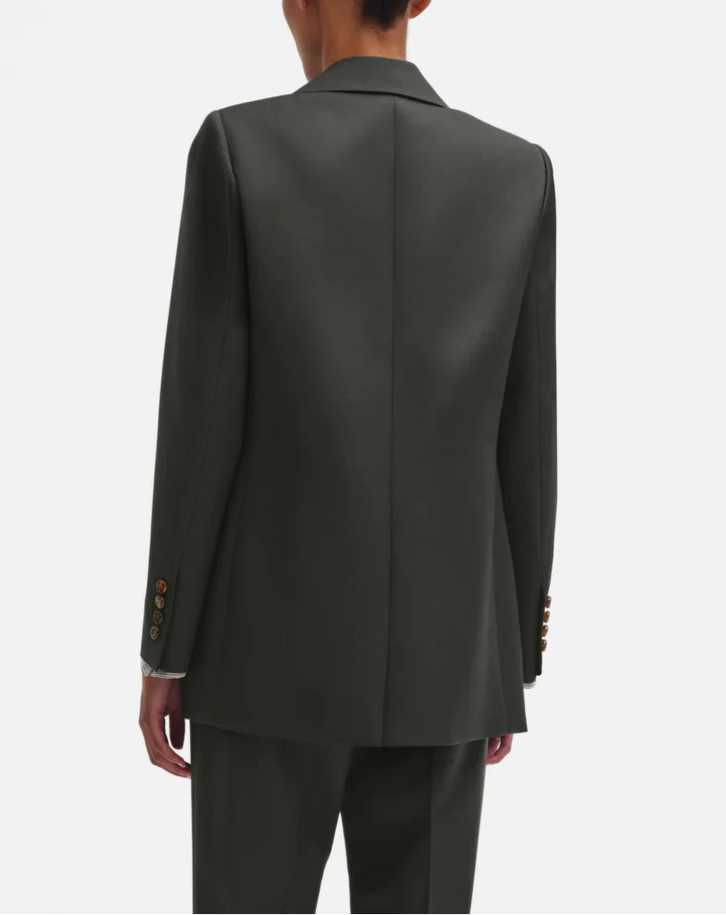 A person is seen from behind wearing a Nahalin Everyday Blazer in dark green with matching trousers by Blaze Milano, set against a plain white background.
