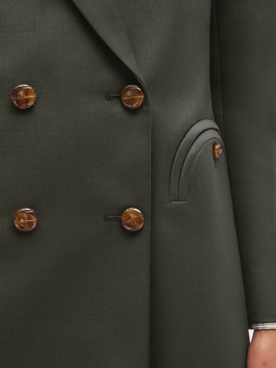 Close-up of the Nahalin Everyday Blazer by Blaze Milano—a dark grey-green double-breasted style with brown marbled buttons and curved flap pockets, offering an elevated twist on a classic blazer.