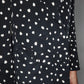 Close-up of the Mariquita Everyday Blazer by Blaze Milano: a black double-breasted style with a white abstract pattern, flap pockets, and black buttons.