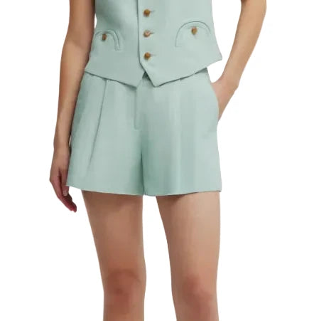 A person wears Blaze Milano's Zenith Selle Shorts in light blue with a matching tailored vest, displaying refined sartorial tailoring and one hand in a pocket.