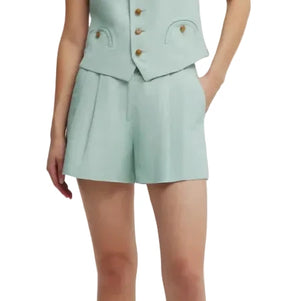 A person wears Blaze Milano's Zenith Selle Shorts in light blue with a matching tailored vest, displaying refined sartorial tailoring and one hand in a pocket.