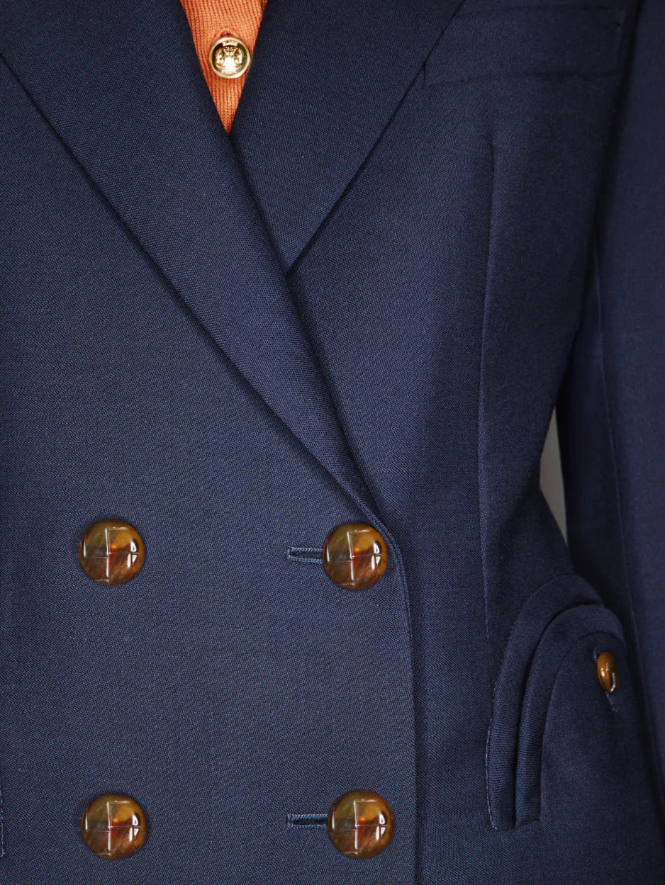 Close-up of the Blaze Milano First Class Charmer Blazer, a slim-fit deep navy piece with brown buttons, revealing a hint of an orange shirt underneath.
