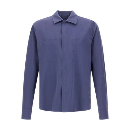 The Herno Seersucker Shirt Jacket is a long-sleeved, button-up style crafted in solid blue, featuring two chest pockets. Shown against a plain white background, this lightweight and versatile piece is ideal for effortless layering.
