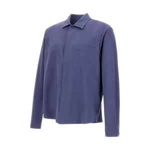 The Herno Seersucker Shirt Jacket features long sleeves, a button-up front, and a textured blue seersucker fabric. It includes a collar and two chest pockets, and is displayed against a plain white background. This lightweight design is breathable for all-day comfort.