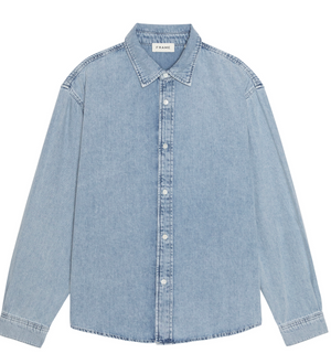 Introducing the Classic Denim Shirt by Frame—a light blue long-sleeve denim shirt offering a relaxed fit. This shirt features a pointed collar, visible stitching, and an interior neckline label reading “FRAME.” Expertly crafted from 100% cotton for enduring comfort and timeless style.