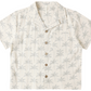 The Rylee & Cru Boys' Lapel Collar Shirt features short sleeves, a button-up front, and a light beige background with a subtle palm tree pattern.