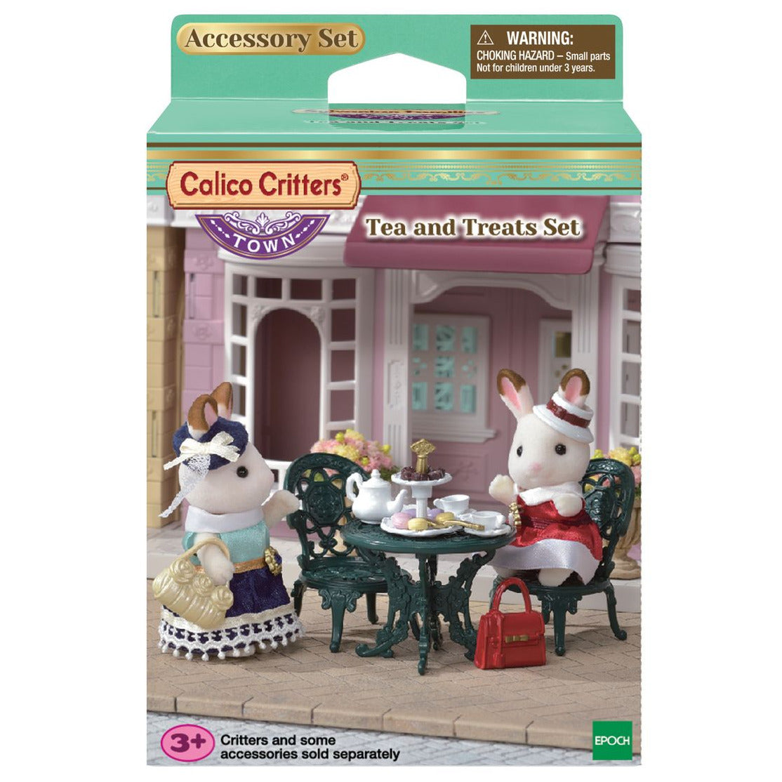 Two rabbit figurines are seated at a garden table with tea and treats outside a pink building. The packaging displays the name “Tea and Treats Set” from Calico Critters and contains delightful tea party accessories to complete the charming scene.